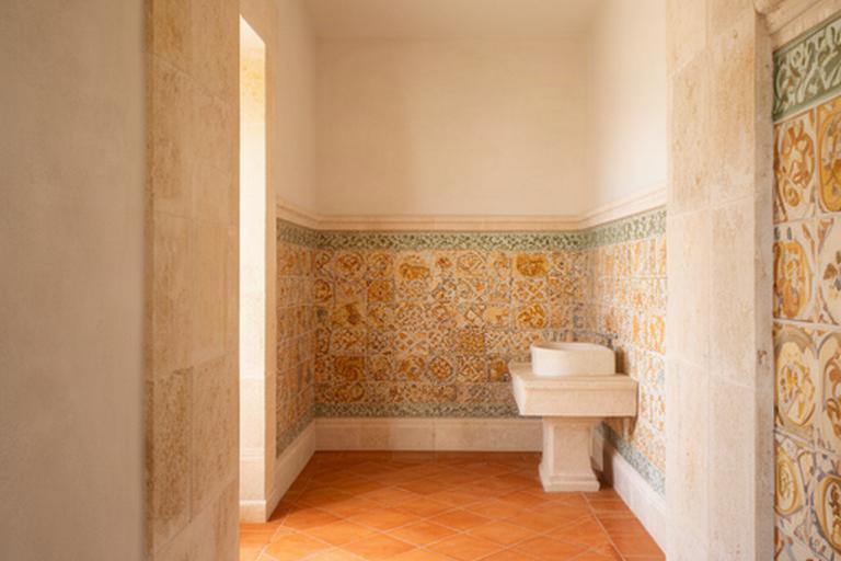 Pavimento in cotto smaltato e rivestimento decorato in un bagno luminoso di una villa salentina